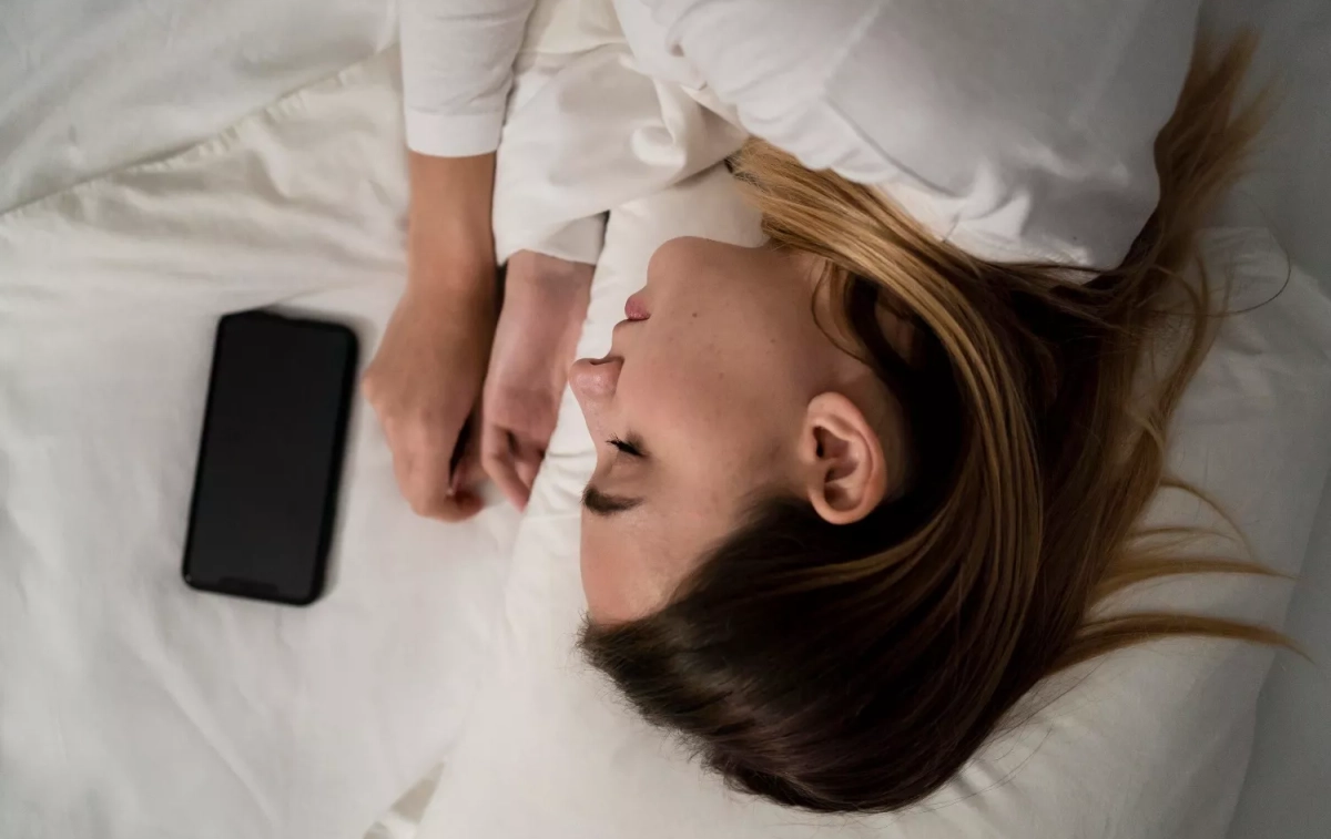 Una chica duerme junto a su móvil / FREEPIK Una chica duerme junto a su móvil / FREEPIK