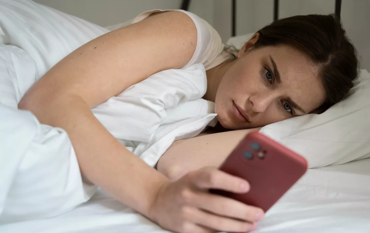 Una mujer apaga la alarma de su móvil / FREEPIK Una mujer apaga la alarma de su móvil / FREEPIK