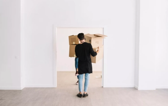 Un inquilino mueve cajas en el interior de un piso semivacío / FREEPIK