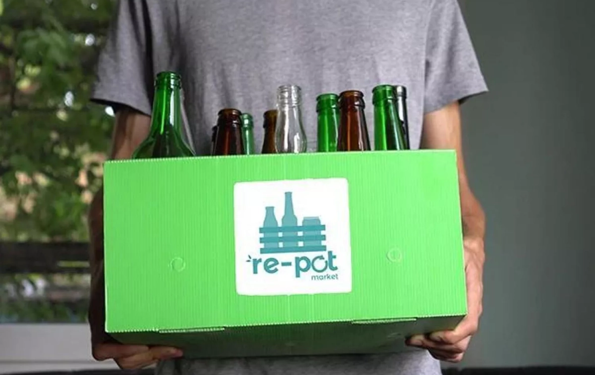 Un consumidor con botellas del supermercado Re pot market / RPM Un consumidor con botellas del supermercado Re pot market / RPM