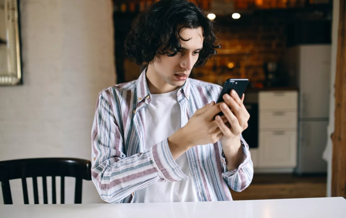 Un joven mira su móvil tras recibir un SMS sospechoso / FREEPIK - karlyukav Un joven mira su móvil tras recibir un SMS sospechoso / FREEPIK - karlyukav