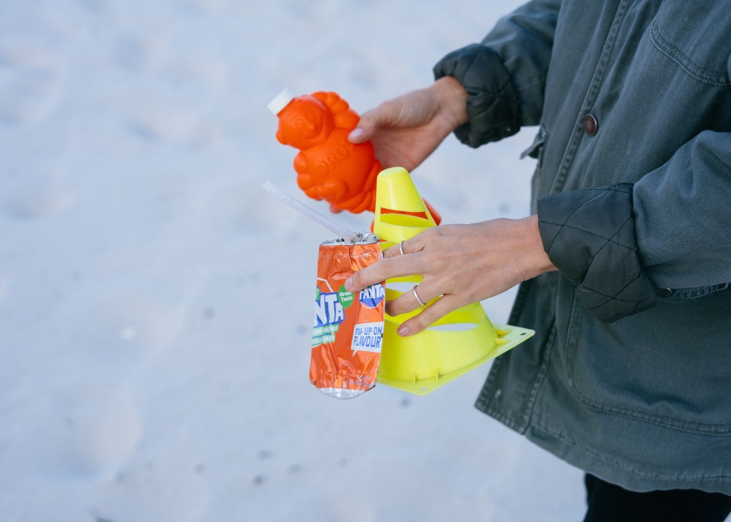 Una mujer que recoge plásticos en la playa / FREEPIK