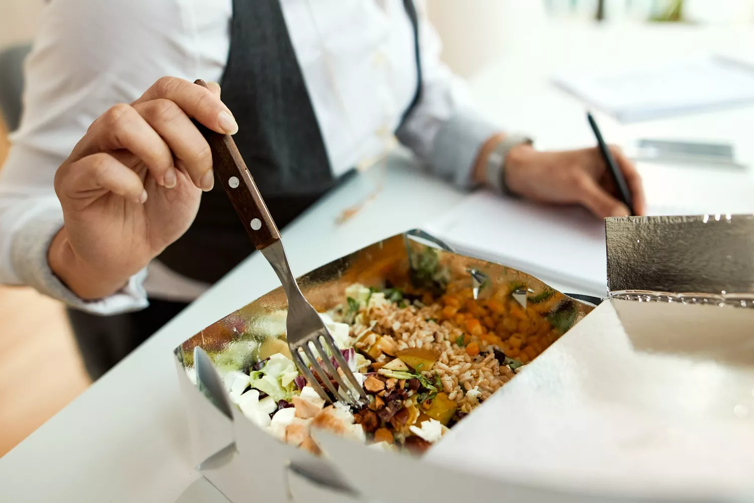 Una persona se come su  tupper de comida saludable/ FREEPIK