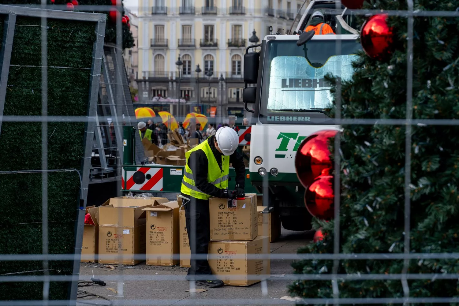 Un operario coloca la iluminación del árbol de Navidad en Madrid, en la cual repercute el precio de
