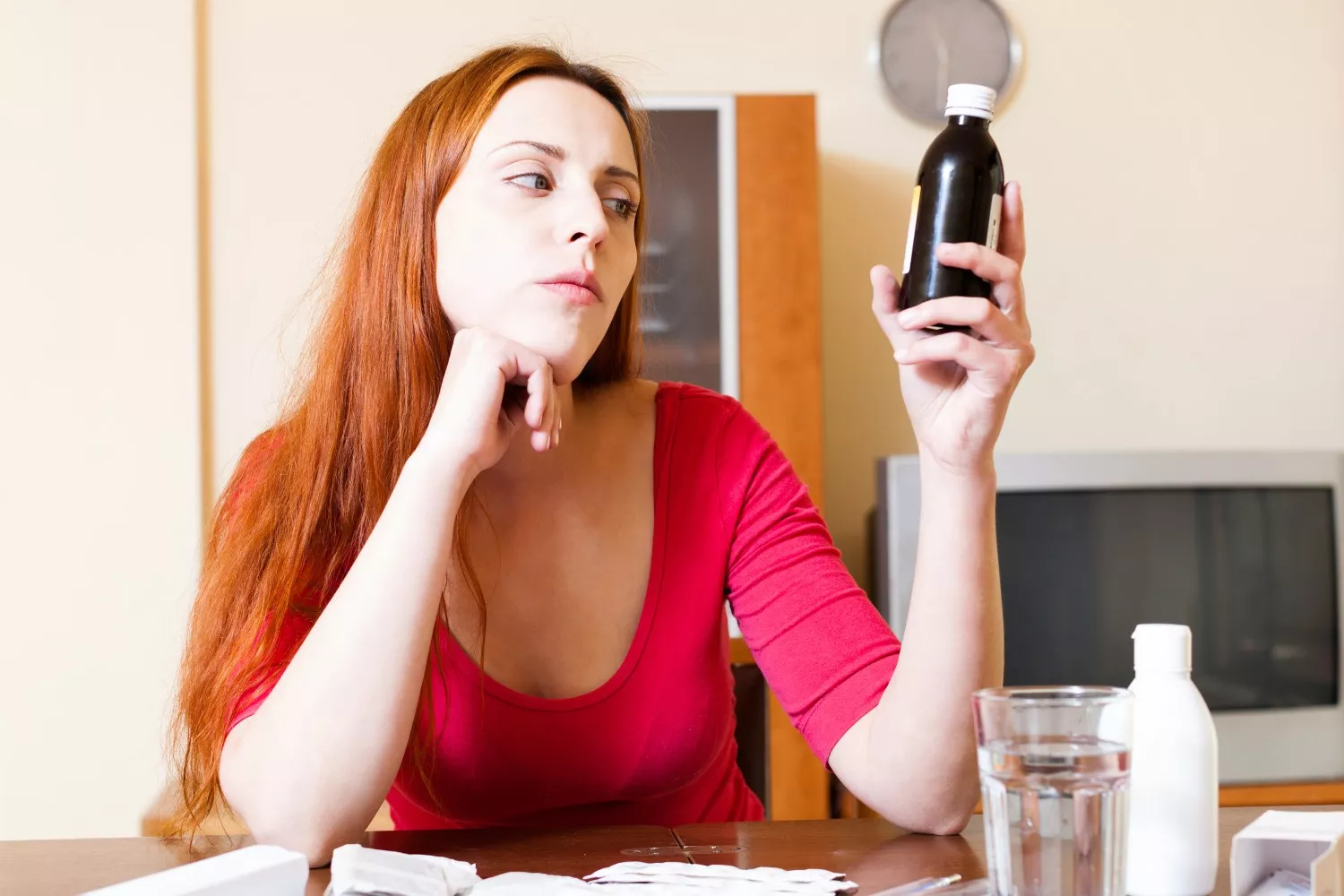Una mujer observa un frasco con suplementos vitamínicos / FREEPIK -  bearfotos