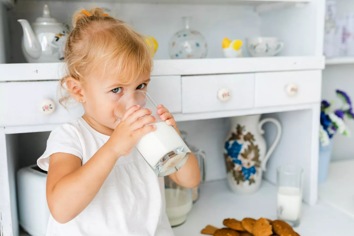 Una niña con un vaso de leche entera/ FREEPIK