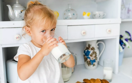 Una niña con un vaso de leche entera/ FREEPIK Una niña con un vaso de leche entera/ FREEPIK
