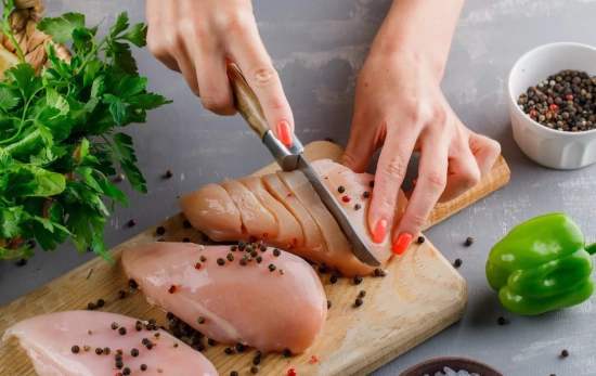 Una persona corta pechugas de pollo / FREEPIK Una persona corta pechugas de pollo / FREEPIK