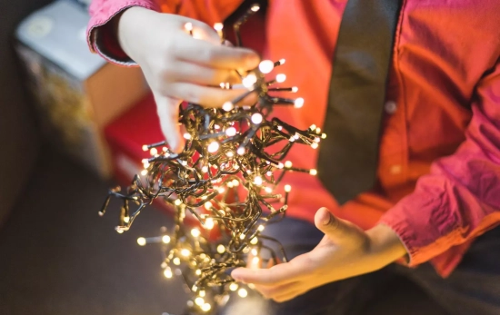 Una persona colocando las luces de Navidad en su árbol / FREEPIK Una persona colocando las luces de Navidad en su árbol / FREEPIK