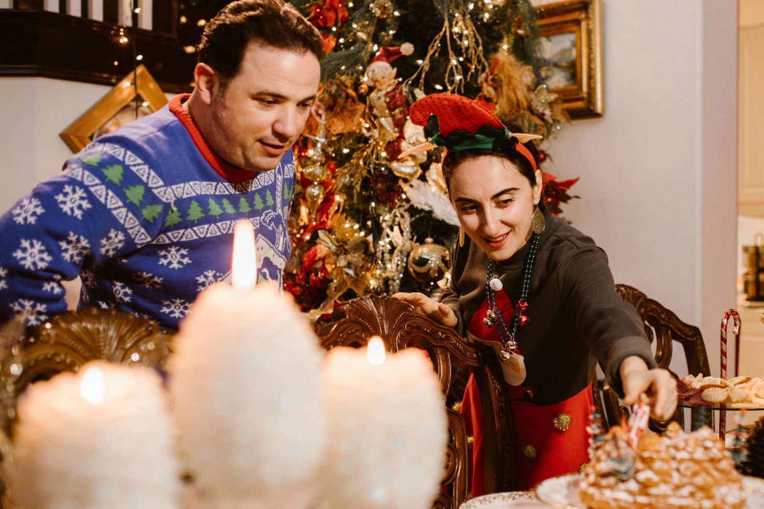 Dos personas montan la mesa con ilusión en su hogar en Navidad/ PEXELS