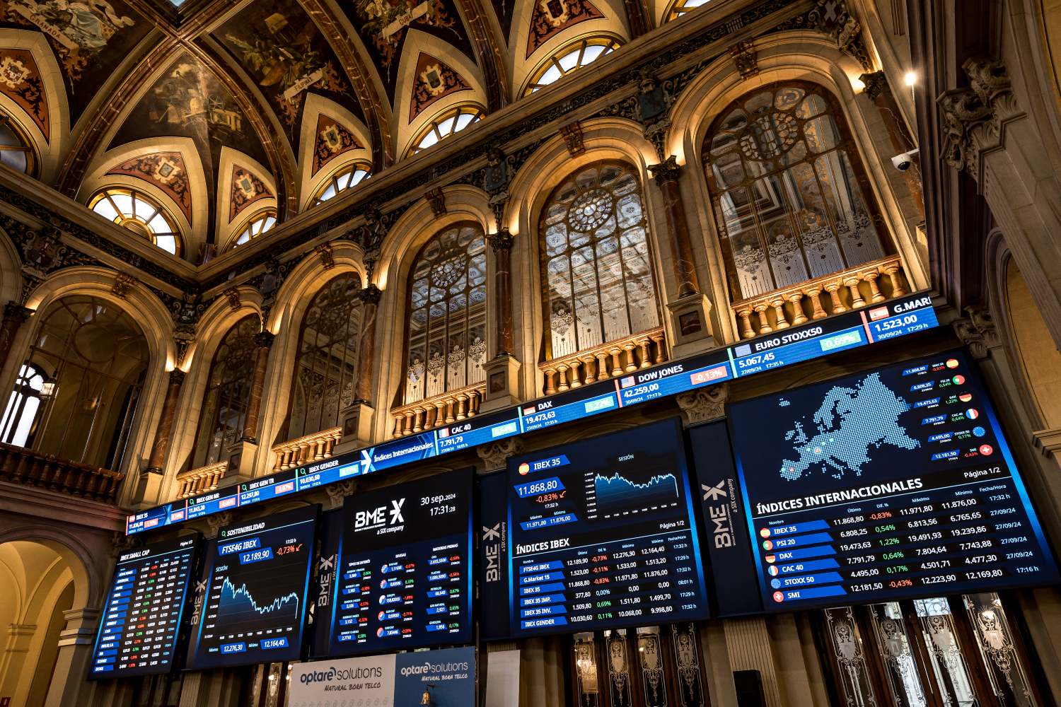 Paneles del Ibex en el Palacio de la Bolsa de Madrid, donde cotizan algunas de las empresas que mayores dividendos darán / EUROPA PRESS - DIEGO RADAMÉS