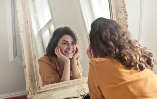 Una mujer que se siente feliz y plena se mira al espejo/ PEXELS Una mujer que se siente feliz y plena se mira al espejo/ PEXELS
