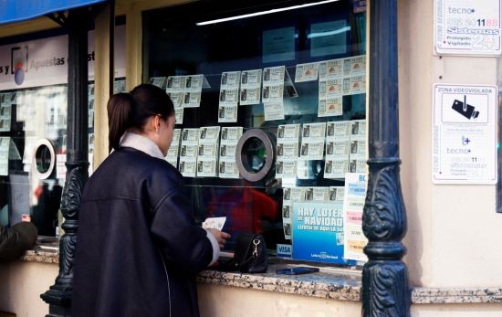 Una chica busca unas terminaciones concretas para el sorteo de Lotería de Navidad / EUROPA PRESS - ÁLEX ZEA