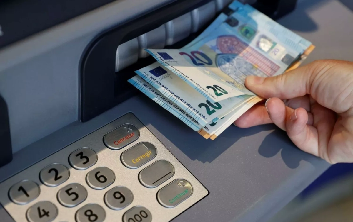 El banco le da a una persona una cantidad de dinero / Emilio Naranjo - EFE