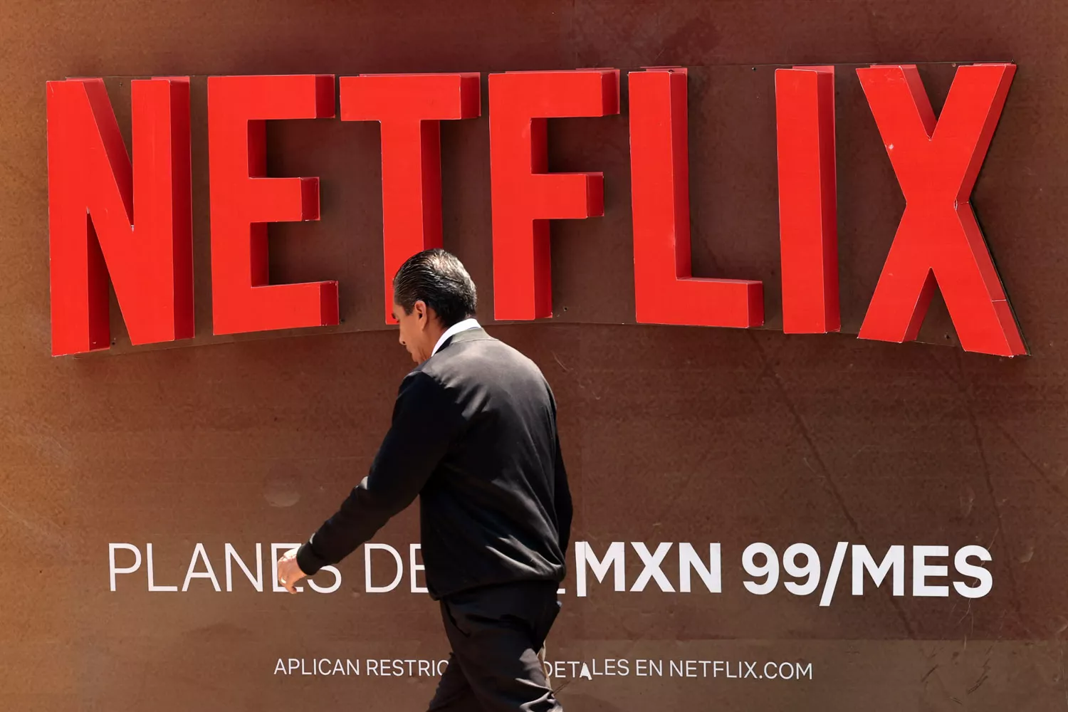 Una persona pasa frente al logotipo de Netflix / JOSÉ MÉNDEZ - EFE