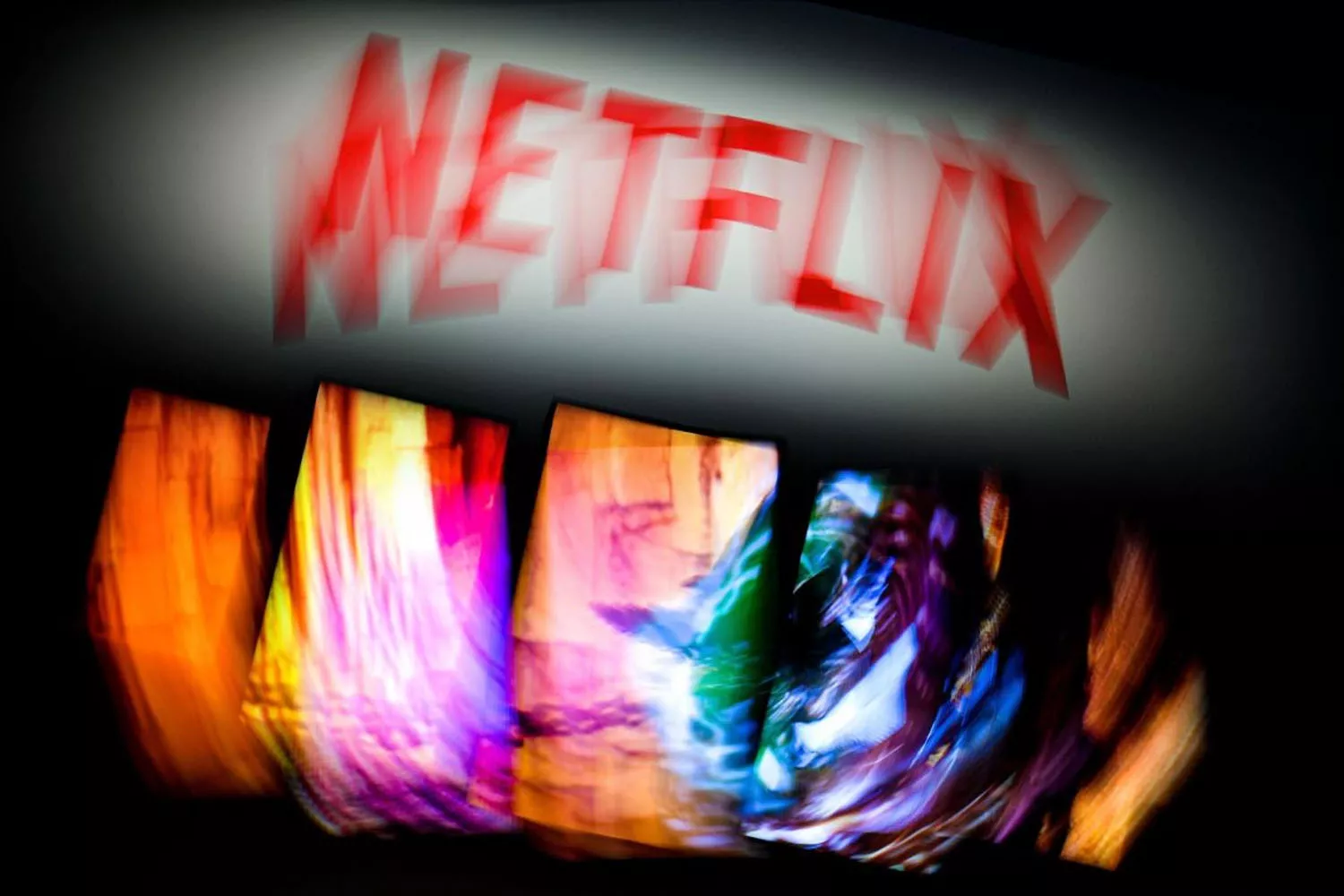 El logo de Netflix borroso y varias pantallas con series / EFE