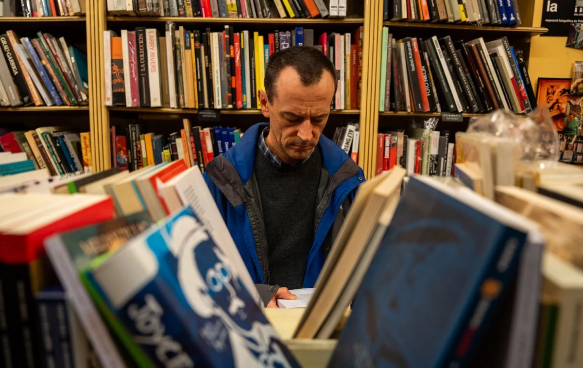 Un cliente hojea un libro en la librería Sant Jordi / GALA ESPÍN Un cliente hojea un libro en la librería Sant Jordi / GALA ESPÍN