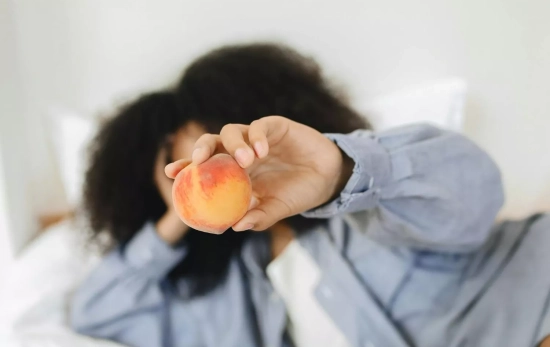 Una chica disfruta de una fruta mientras descansa/ PEXELS Una chica disfruta de una fruta mientras descansa/ PEXELS