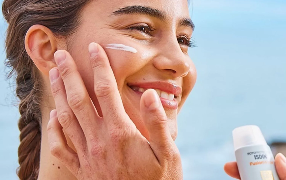 Una persona se pone crema Isdin sobre el rostro / ISDIN Una persona se pone crema Isdin sobre el rostro / ISDIN