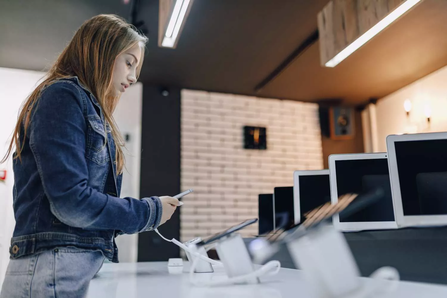 Una chica visita una tienda de aparatos electrónicos / FREEPIK