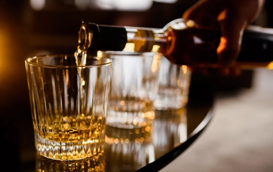 Una persona sirve alcohol de una botella sin dosificador / FREEPIK Una persona sirve alcohol de una botella sin dosificador / FREEPIK