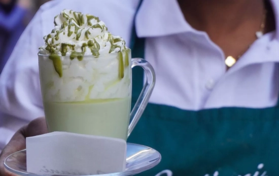 Una empleada con una taza de pistacho caliente / BADIANI Una empleada con una taza de pistacho caliente / BADIANI