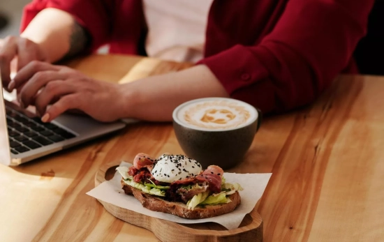 Una persona comiendo mientras trabaja/ PEXELS Una persona comiendo mientras trabaja/ PEXELS