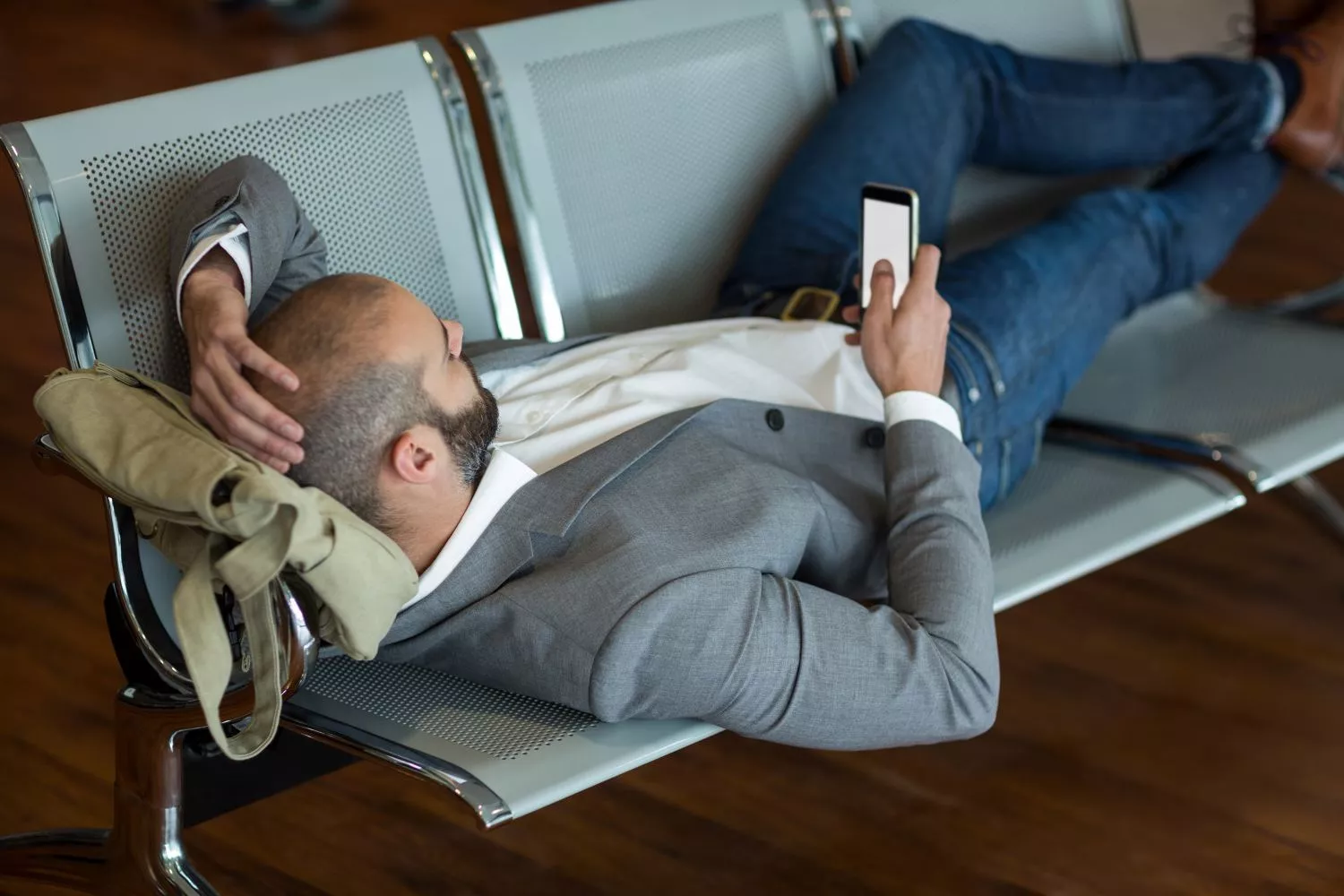Una persona se dispone a dormir en el aeropuerto / FREEPIK - wavebreakmedia_micro