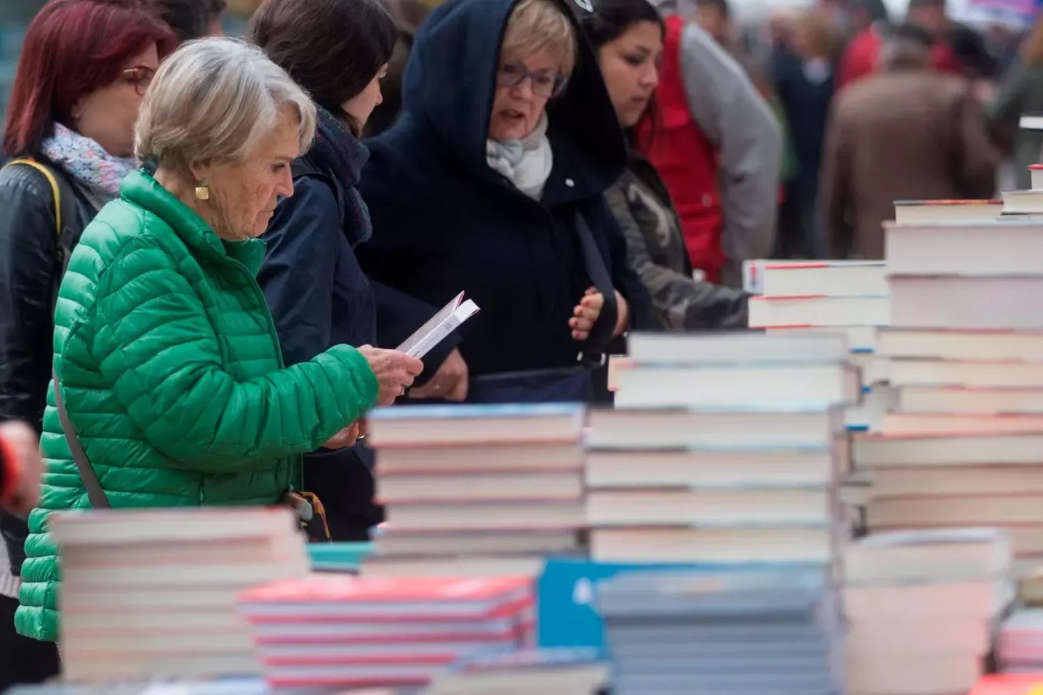 Varias personas mirando libros en una parada en la calle / EFE
