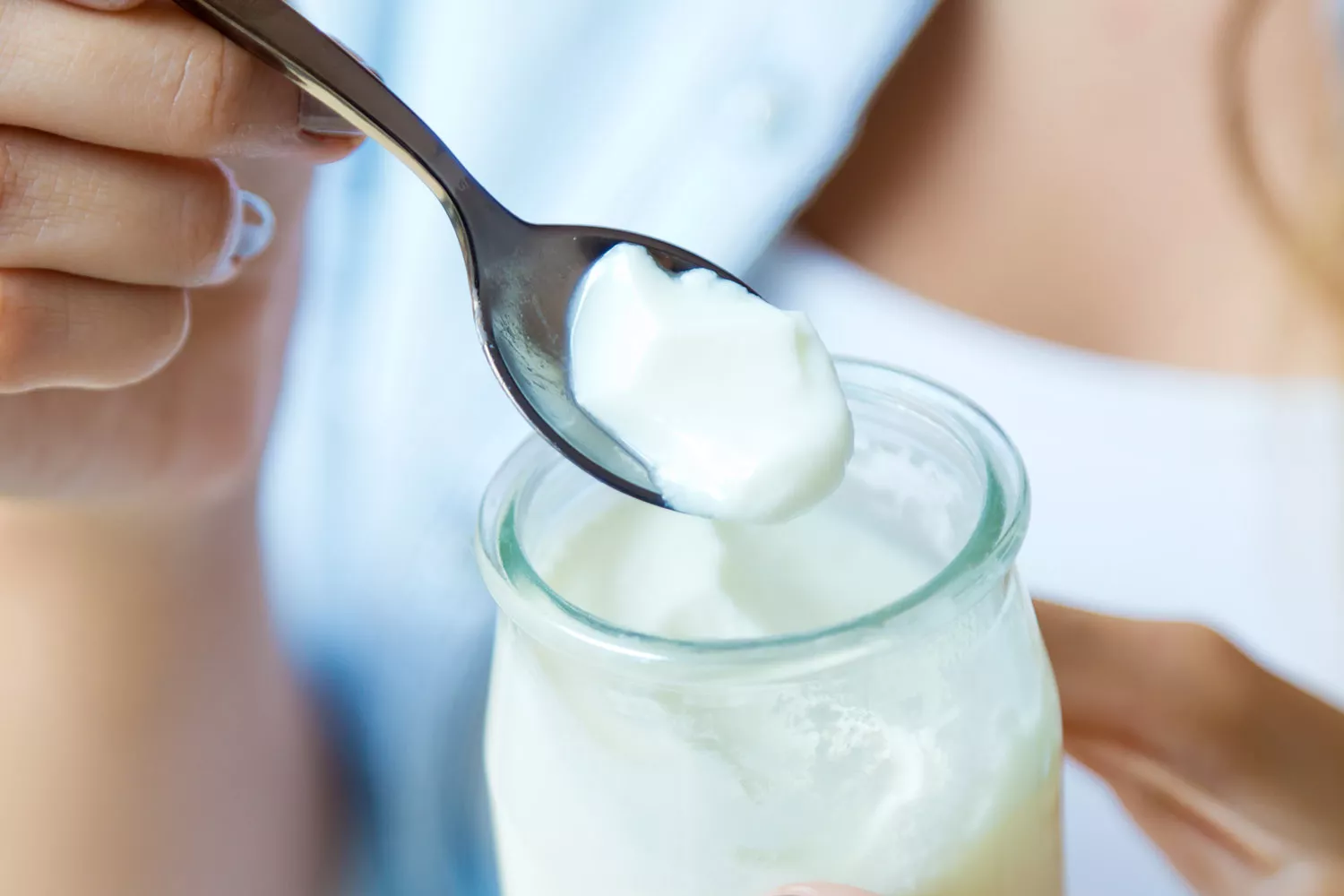 Una persona tomando un yogur / FREEPIK