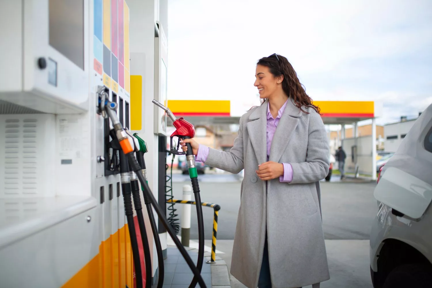 Uma mulher abastece-se numa bomba de gasolina low cost / FREEPIK