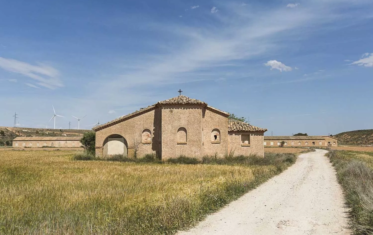 La iglesia del campo en primer plano, los barracones y molinos de viento / TURISMO BELCHITE La iglesia del campo en primer plano, los barracones y molinos de viento / TURISMO BELCHITE