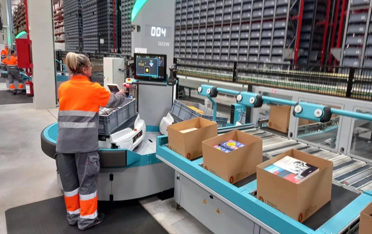 Una empleada extrae libros de las cajas que transportan los robots / TC Una empleada extrae libros de las cajas que transportan los robots / TC