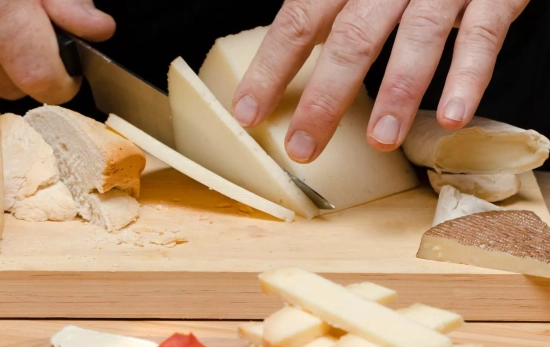 Una persona parte queso / FREEPIK Una persona parte queso / FREEPIK
