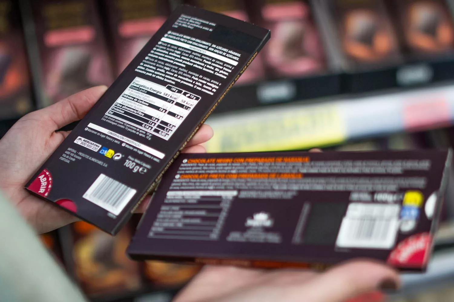 Una persona consulta la información nutricional de una tableta de chocolate MERCADONA