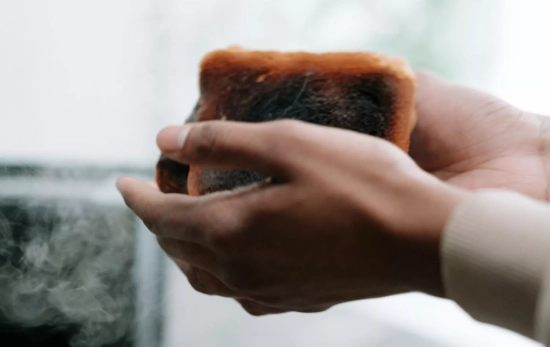 Una persona sostiene dos tostadas que se han quemado/ PEXELS Una persona sostiene dos tostadas que se han quemado/ PEXELS