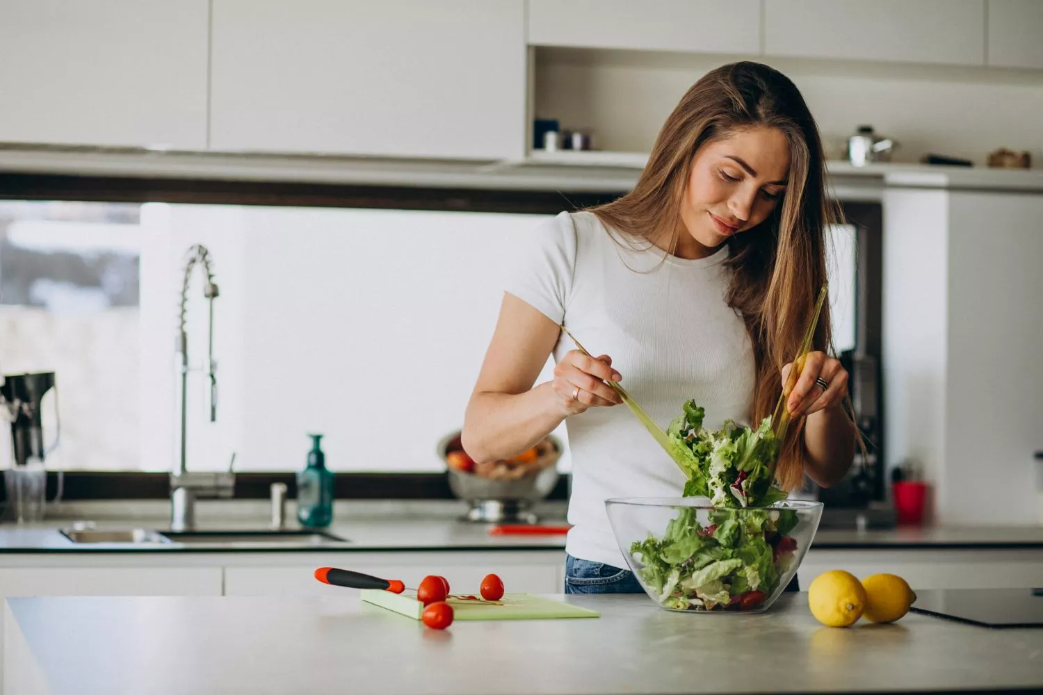 Una mujer prepara una ensalda con alimentos saludables / FREEPIK -  senivpetro