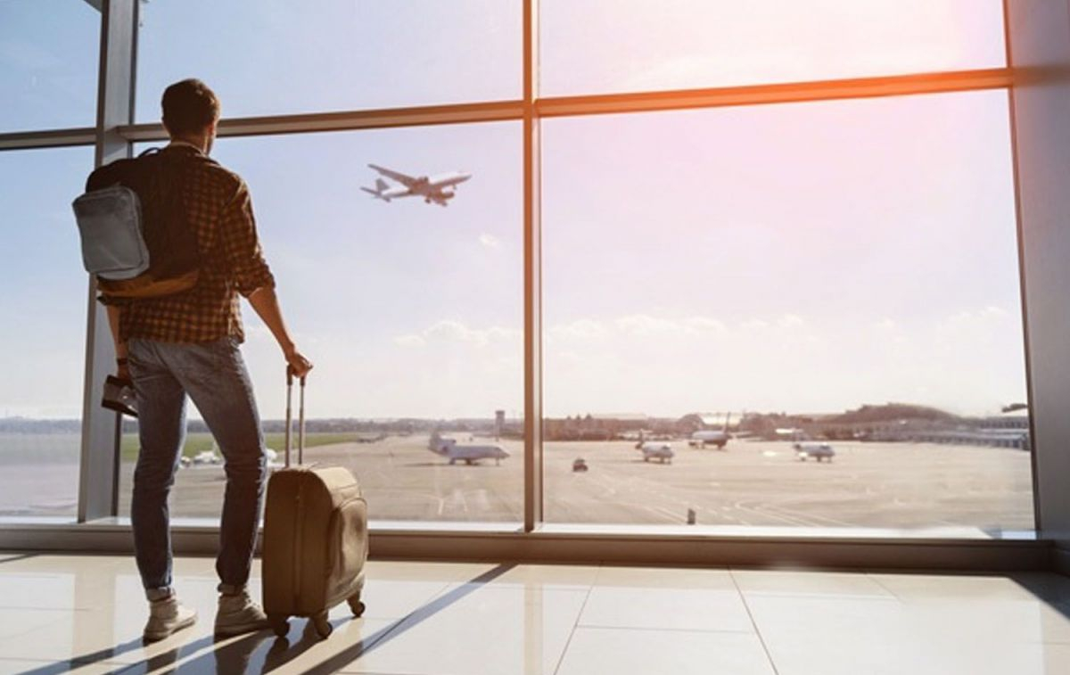 Un hombre con sus maletas mira como despega un avión de Vueling / EP