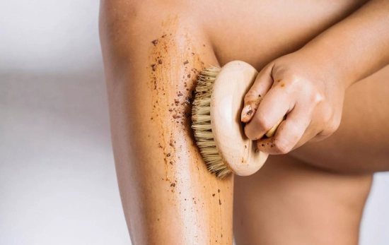 Una mujer aplicándose una crema de café y té verde casera con un cepillo en seco/ PEXELS Una mujer aplicándose una crema de café y té verde casera con un cepillo en seco/ PEXELS
