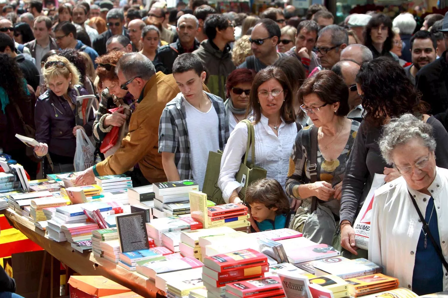 Personas en una parada de libros de la Rambla de Barcelona durante la Diada de Sant Jordi / EFE - TONI ALBIR