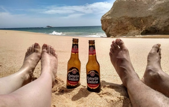 Dos personas con dos cervezas en la playa / UNSPLASH Dos personas con dos cervezas en la playa / UNSPLASH