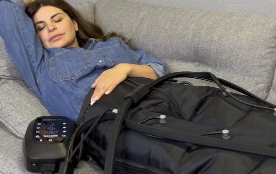 Una mujer usando una máquina de presoterapia/ SKINVITY Una mujer usando una máquina de presoterapia/ SKINVITY