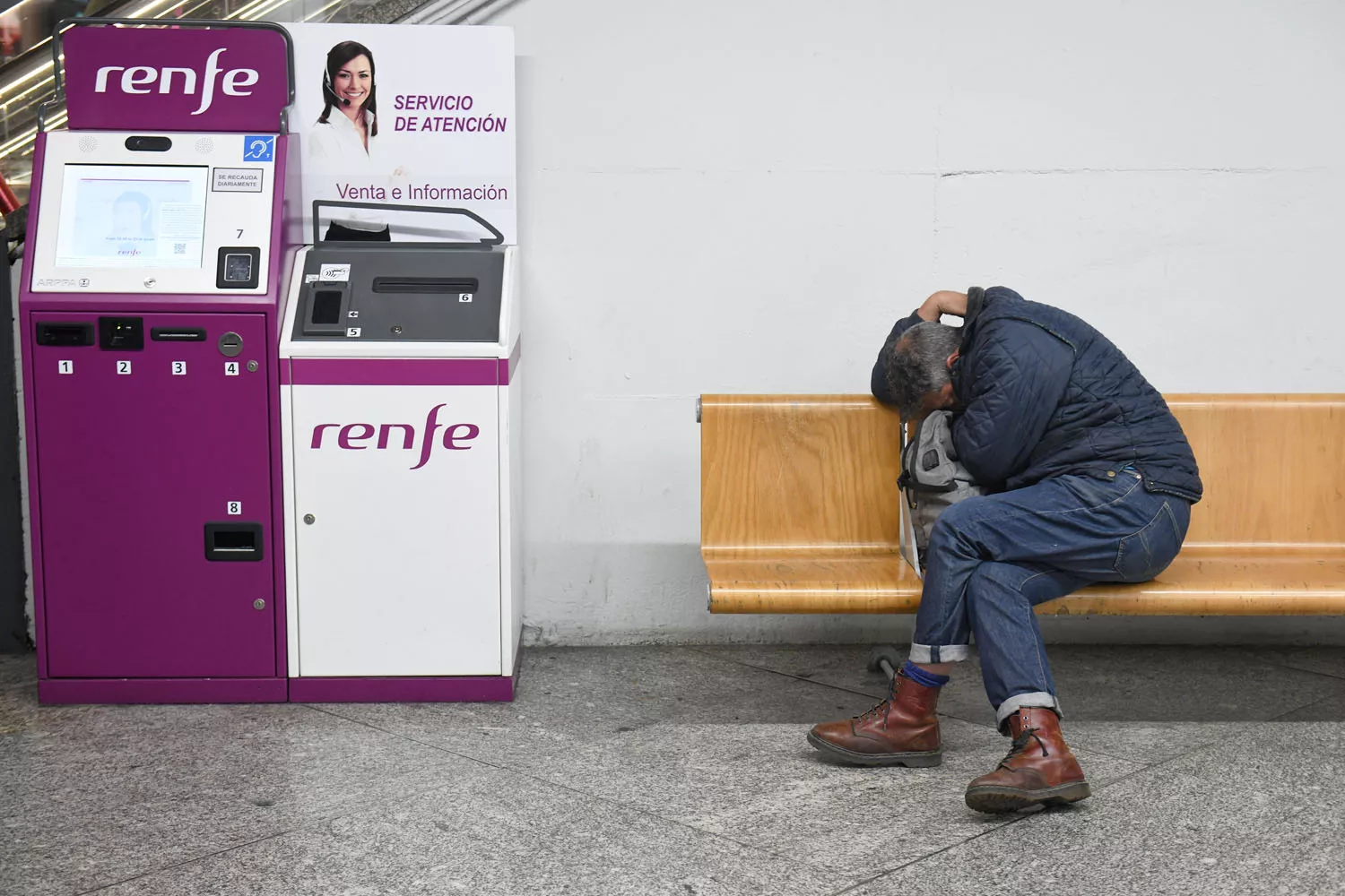 Un hombre en una silla de la estación de Atocha Almudena Grandes, tras los retrasos en los trenes AVE, junto a una máquina de Renfe FERNANDO SÁNCHEZ EP