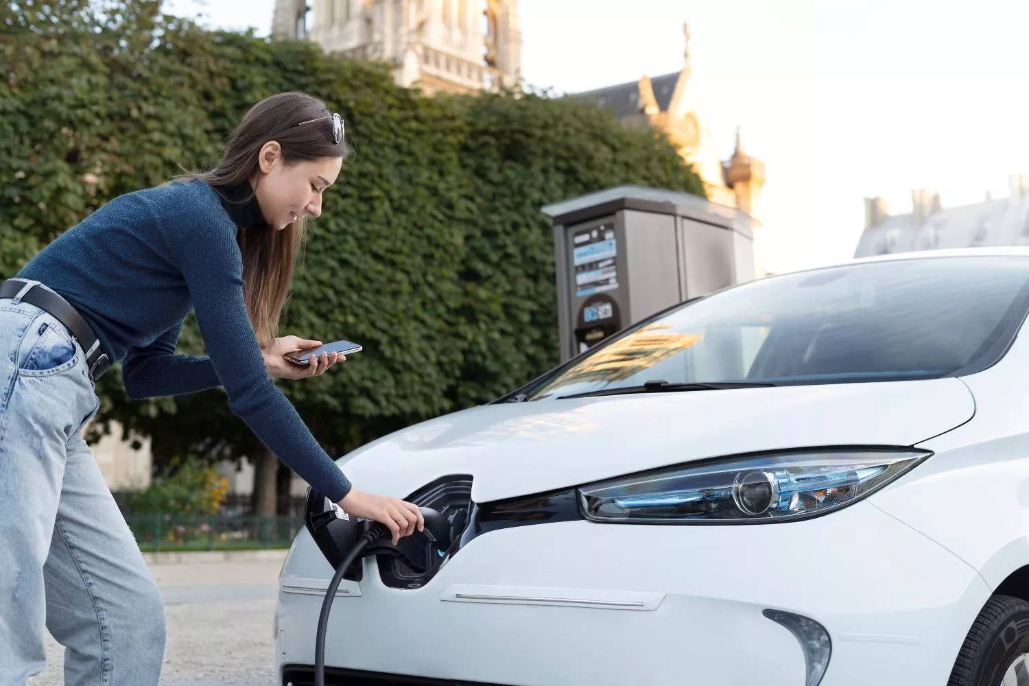 Una persona carga un coche eléctrico / FREEPIK