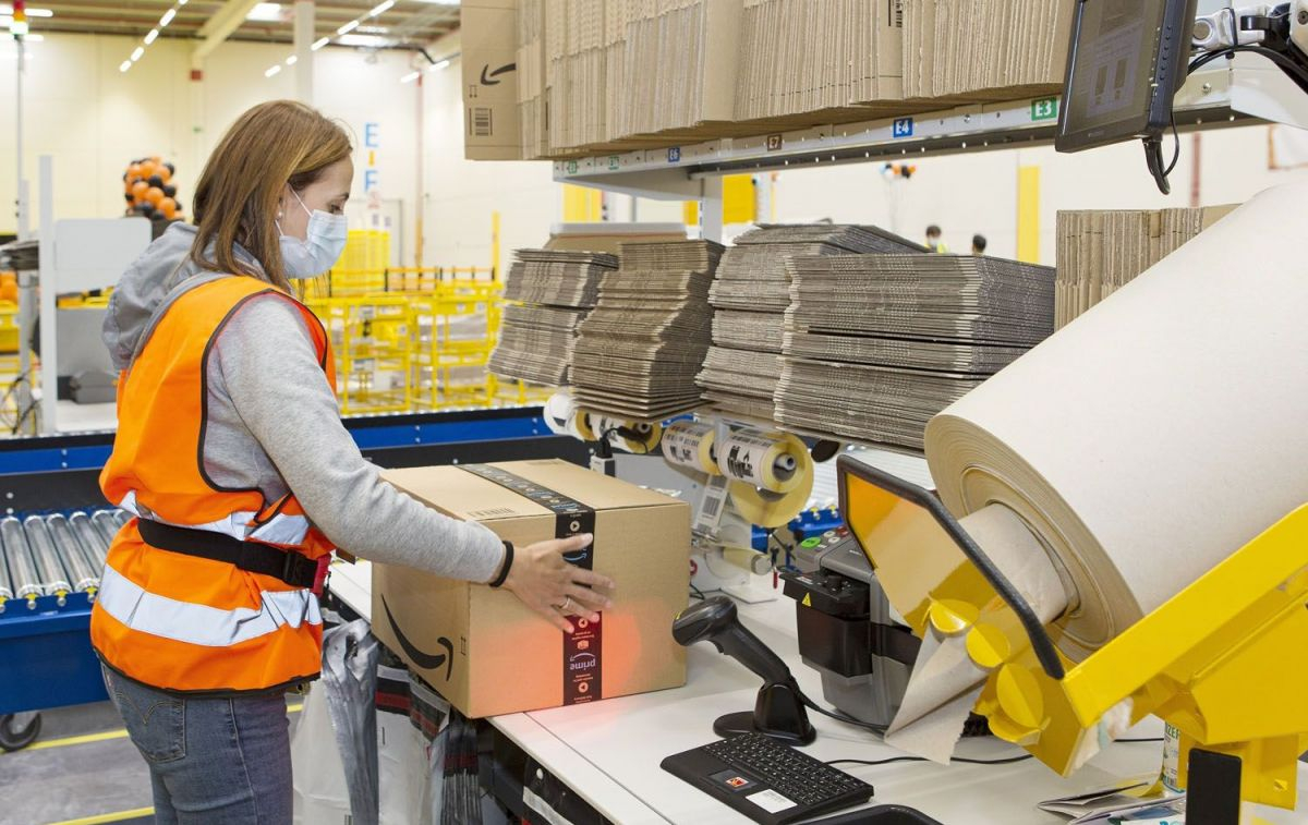 Una trabajadora precinta un paquete de Amazon / EP