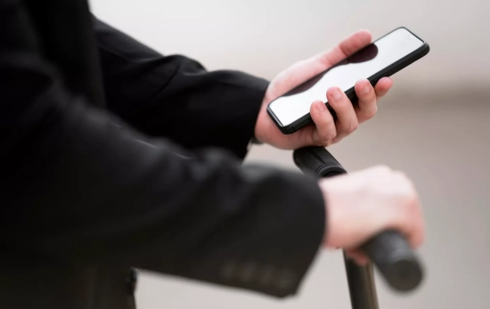 Una persona mira algo sospechosos en la pantalla de su teléfono móvil / FREEPIK