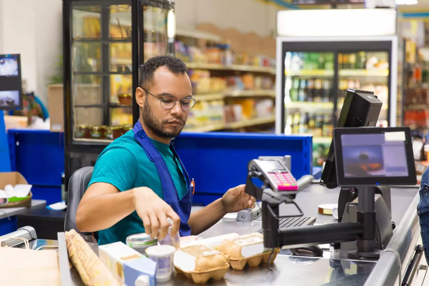 Un chico que trabaja de cajero en un supermercado   FREEPIK