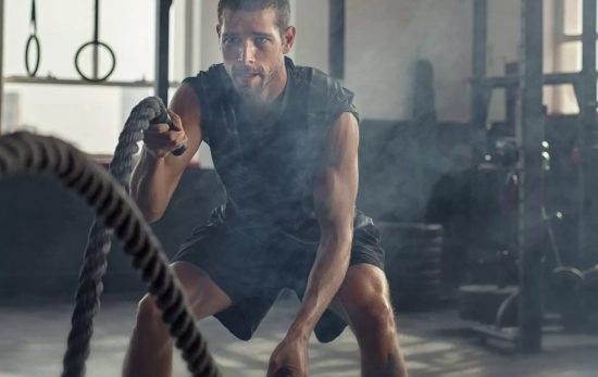 Un hombre haciendo ejercicio intenso en clase de crossfit/ CANVA Un hombre haciendo ejercicio intenso en clase de crossfit/ CANVA