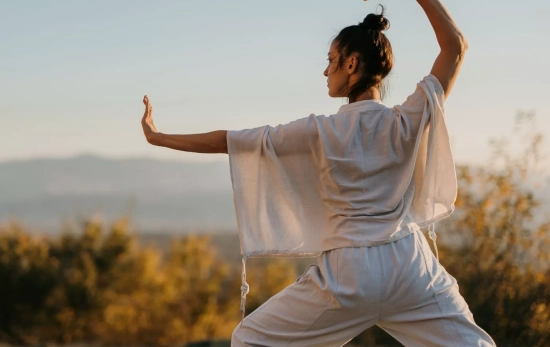Una mujer mejorando su equilibrio haciendo tai chi/ PEXELS Una mujer mejorando su equilibrio haciendo tai chi/ PEXELS