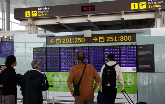 Varias personas miran los paneles informativos en el aeropuerto de Barcelona El Prat Varias personas miran los paneles informativos en el aeropuerto de Barcelona El Prat
